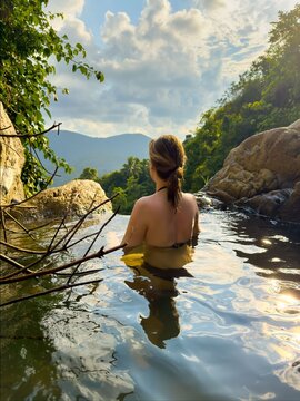 Young Woman Enjoys Sunset View in Natural Jungle Infinity Pool