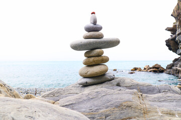 Balanced stones stacked on the beach with calm sea background, symbolizing harmony, balance, and mindfulness in nature. Perfect concept for wellness, meditation, and tranquility themes.