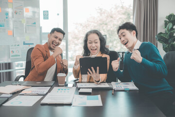 Group of successful Asian businesspeople smiling and laughing, posing and making gestures of joy together in a company office conference room.