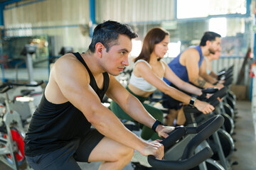 Obraz premium People training on stationary bikes indoor cycling class