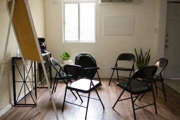 Empty chairs in group addiction therapy meeting room