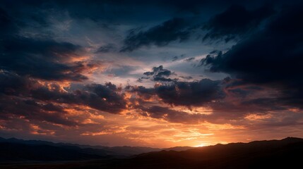 Fototapeta premium Dramatic sunset paints the sky with vibrant colors over a silhouetted mountain range