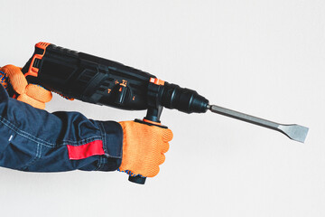 rotary hammer. Hands in protective gloves with  perforator.