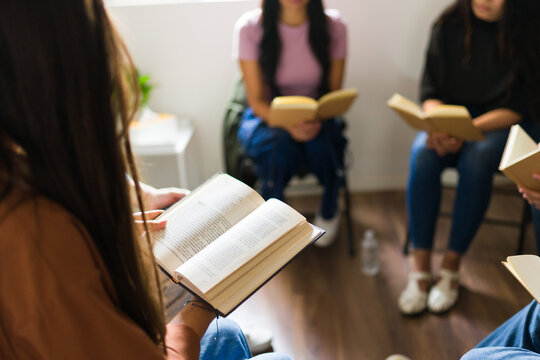 Closeup of women reading books in a focused book club