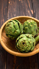 Fototapeta premium Fresh Green Artichokes in Bamboo Bowl on Wooden Table 
