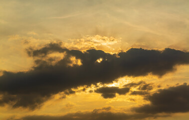 Obraz premium Gray clouds reflect orange light at sunset,Beautiful orange and gray skies at sunset.