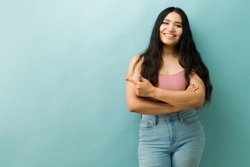 Happy latina woman smiling and pointing content