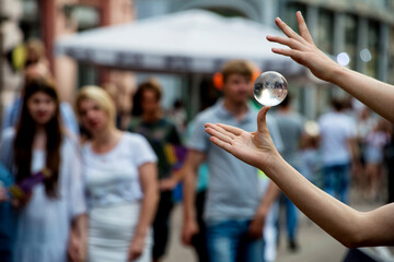 Street Performer Contact Juggling a Clear Crystal Ball in a Crowd