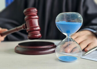 Courtroom scene with a gavel and hourglass showing the passage of time in a legal