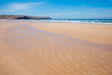 ribbed sandy bottom on the Bordeira beach. outgoing waves. landscape portugal