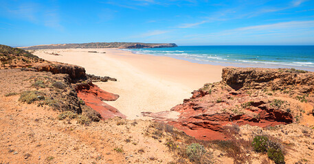 lonely Bordeira sand beach with red sandstone, West Algarve coast Portugal