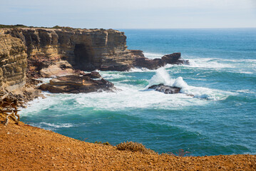 West Algarvve coast with steep cliffs and breaking waves. Portugal