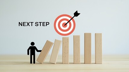 Man holding block for domino effect with target and arrow in background