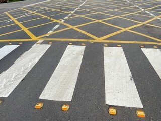 Pedestrian Crosswalk and Yellow Grid Road Markings on Asphalt