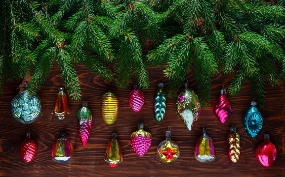Fresh fir branches and vintage Christmas toys on a dark wooden background.
