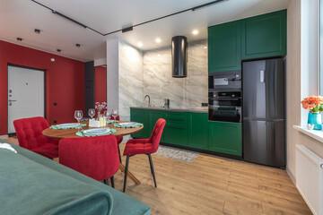 Modern Kitchen and Dining Area with Green Cabinets and Red Chairs