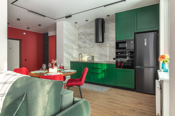 Modern Kitchen and Living Area with Green Cabinets and Red Chairs