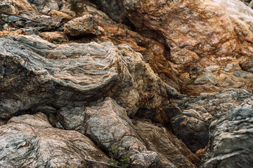 Close view of folded layered rocks along rocky shoreline. High quality photo