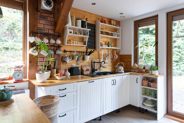 interior of modern kitchen in vintage style with white wooden furniture and rustic detail. Bright...