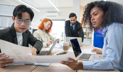 Multi-ethnic business team in office meeting, reviewing documents and brainstorming innovative...