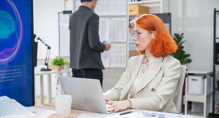Professional businesswoman working on laptop in modern office, focused on tasks and productivity,...