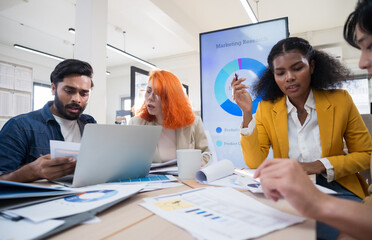 Multi-ethnic business team in office meeting, reviewing documents and brainstorming innovative...