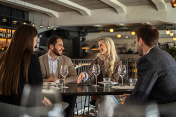 Group of friends enjoying a meal and conversation at a stylish restaurant