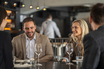 Friends enjoying a meal and conversation at a stylish restaurant