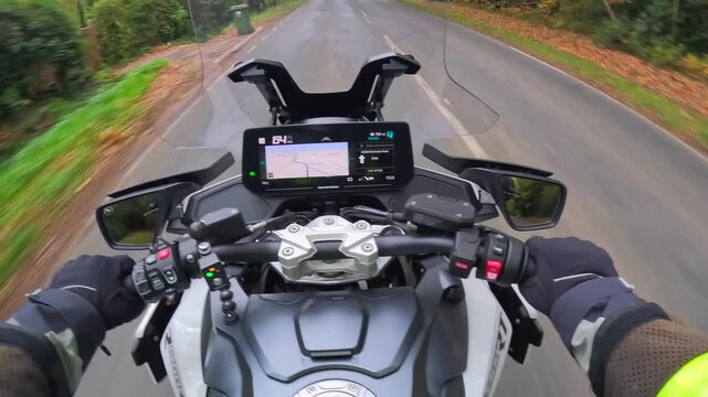 Dynamic first-person view from a motorcycle riding along a road in the UK on a beautiful fall day. Showing dashboard and the road.