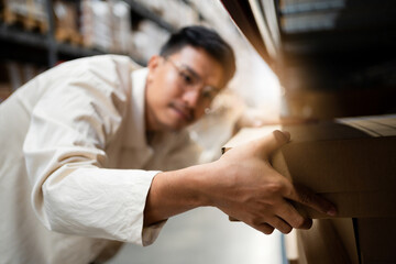 A man is reaching for a box on a shelf