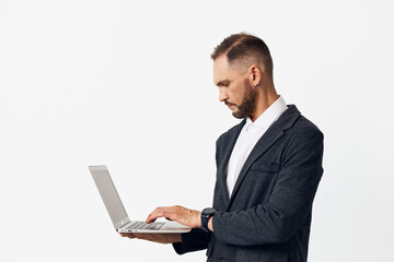 A business professional man stands with a laptop, focused expression, on a clean white background....