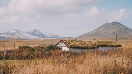 Rustic Grass-Roofed House in a Vast Mountain Landscape