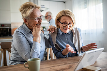 Senior women friends making video call on tablet
