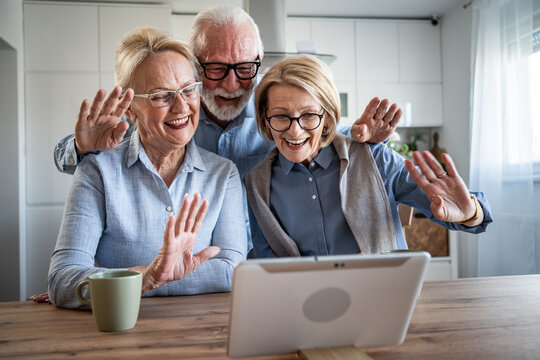 Senior couple and friend video calling family with tablet - Powered by Adobe