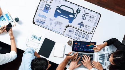 Group of professionals collaborating on automotive innovation using digital analytics and data visualization tools in a modern office setting, highlighting teamwork. Raster