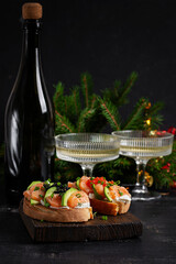 Avocado and salmon appetizer on the Christmas table. Canapes with fish and caviar. Top view