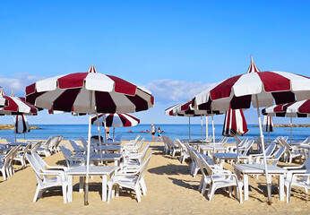 Seaside outdoor cafe with beach chairs, sun umbrellas and tables on perfect Tel Aviv's beautiful Mediterranean public sandy beach
