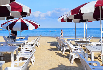 Seaside outdoor cafe with beach chairs, sun umbrellas and tables on perfect Tel Aviv's beautiful Mediterranean public sandy beach
