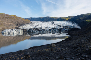 Scenic view of a glacier reflecting in a pristine lake on a clear day.