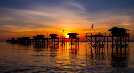 Obraz premium Sunset over stilt houses in the sea