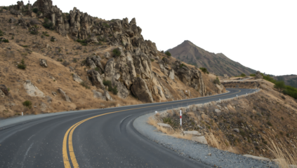 Curved asphalt road with yellow lines passes by rugged rocky cliffs and dry vegetation on a mountain slope png