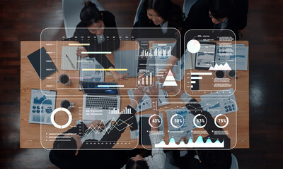 A diverse business team engages in a data-driven meeting. They use technology to analyze charts and graphs, aiming for strategic insights and collaborative success. Trope