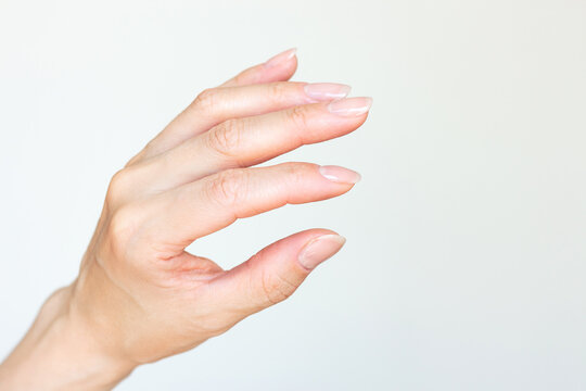 A woman's hand holding something small with two fingers or showing small size. Isolated on a white background. Mockup. Empty copy space
