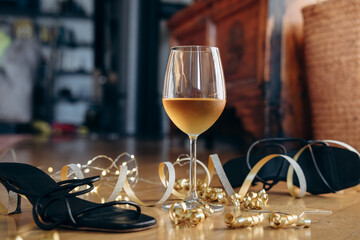 party or after party background birthday wedding Christmas new year  black high-heeled shoes surrounded by festive decorations and a glass of wine, celebratory atmosphere