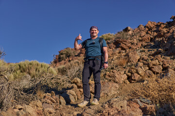 Naklejka premium Hiker showing shaka gesture