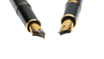 Two black pens with gold accents hover on a black backdrop, focused on their nibs, presenting a close-up shot