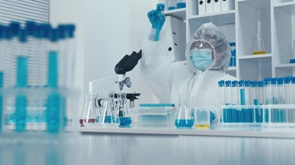 In a top lab, a skilled scientist in a protective suit conducts complex experiments, managing test tubes and analyzing samples with precision and intense focus, showcasing their expertise