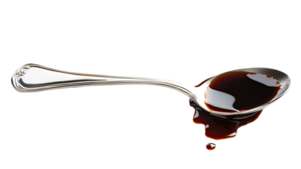 Soya sauce spilled with silver spoon showing glossy dark liquid texture and culinary elegance isolated on white background