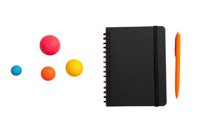 Flat lay Four balls, a black notebook with band, and an orange pen arranged on a black background