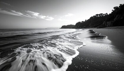 Seaside Waves Washing Ashore Black and White Landscape Photography with Forested Hillside and Dramatic Sky
